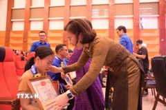 Trao trao Bằng khen cho thanh niên khuyết tật trong Chương trình. (Ảnh: Hạnh Quyên/TTXVN)
