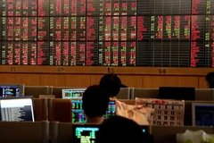 Nhà đầu tư theo dõi biến động chứng khoán trên bảng điện tử. (Ảnh: Reuters)