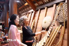 Hướng dẫn du khách trải nghiệm nhạc cụ dân gian của dân tộc Êđê tại bảo tàng Đắk Lắk trong dịp nghỉ lễ 30/4-1/5. (Ảnh: Hoài Thu/TTXVN)