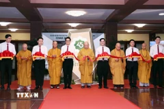 Các đại biểu thực hiện nghi thức cắt băng khai mạc. (Ảnh: Xuân Khu/TTXVN)