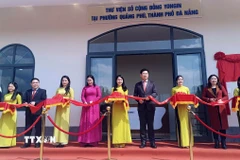 Đại biểu thực hiện nghi thức cắt băng khánh thành thư viện số. (Ảnh: Trần Tĩnh/TTXVN)