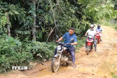 Người dân vẫn hàng ngày di chuyển trên tuyến đường đã xuống cấp. (Ảnh: Đinh Thùy/TTXVN)