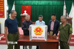 Kiểm tra hòm phiếu tại khu vực bỏ phiếu. (Ảnh: Tiến Vĩnh/TTXVN)