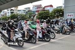 Áo chống nắng, khẩu trang là những vật không thể thiếu của người dân khi tham gia giao thông. (Ảnh: Vũ Quang/TTXVN)