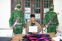 Đối tượng Giàng A Đông cùng tang vật vụ án. (Ảnh: TTXVN phát)