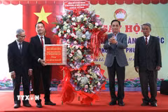 Bộ trưởng Bộ Ngoại giao Lê Hoài Trung trao quà và hoa chúc mừng cho Tổ dân phố Dạ Lê. (Ảnh: Mai Trang/TTXVN)