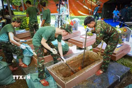 Cán bộ, chiến sỹ khai quật mộ liệt sỹ phục vụ công tác giám định ADN tại Nghĩa trang Liệt sỹ Quốc gia A1. (Ảnh: Xuân Tư/TTXVN)