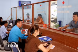 Cán bộ Trung tâm Phục vụ hành chính công xã Lao Chải (Tuyên Quang) hướng dẫn, giải quyết thủ tục hành chính cho người dân. (Ảnh: Đức Thọ/TTXVN)