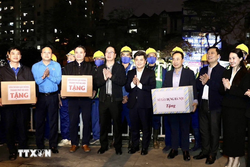 Lãnh đạo Công đoàn Thủ đô thăm, động viên công nhân tại hiện trường nạo vét sông Tô Lịch. (Ảnh: TTXVN phát)