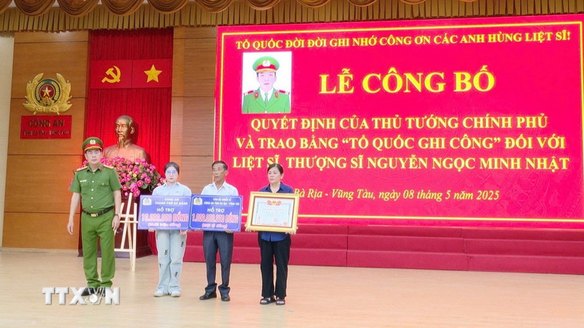 Thượng tá Trần Thanh Hiển, Phó Giám đốc Công an tỉnh Bà Rịa-Vũng Tàu trao Bằng Tổ quốc ghi công và kinh phí hỗ trợ cho thân nhân Liệt sỹ, Thượng sỹ Nguyễn Ngọc Minh Nhật. (Ảnh: Đoàn Mạnh Dương/TTXVN)