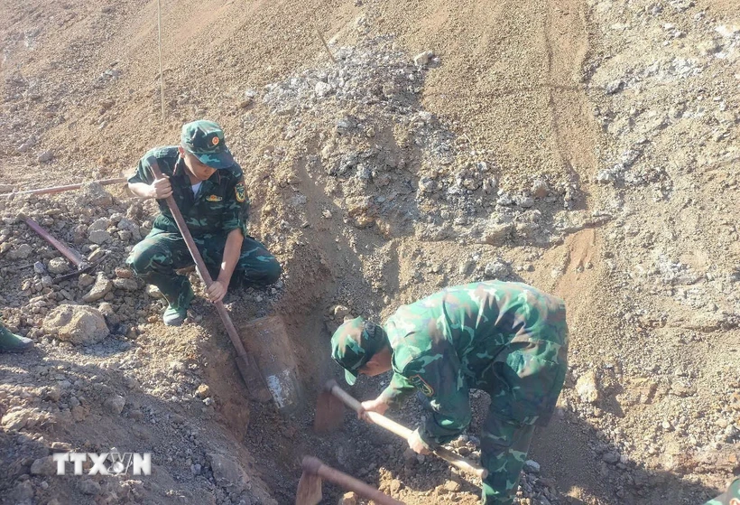 Lực lượng chức năng thu gom, vận chuyển, xử lý an toàn quả bom nặng 227kg tại thôn 3, xã Bom Bo, huyện Bù Đăng. (Ảnh: TTXVN phát)