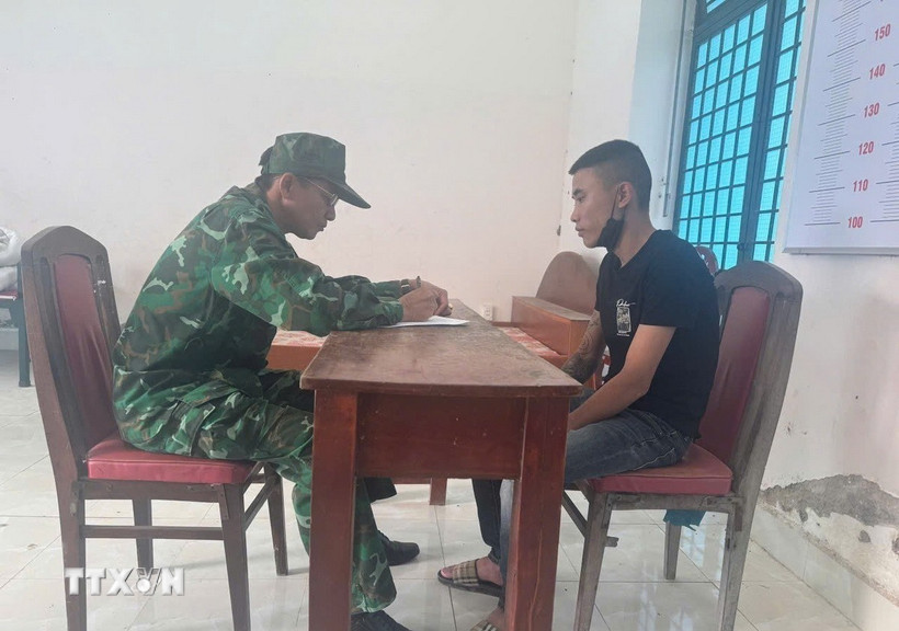 Cán bộ nghiệp vụ thuộc Đồn Biên phòng Cửa khẩu quốc tế Mộc Bài làm việc với đối tượng Phạm Minh Hải. (Ảnh: TTXVN phát)