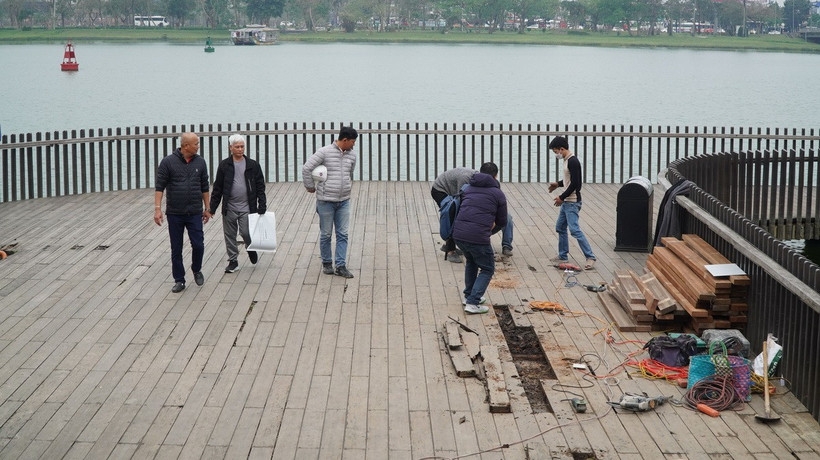 Các đơn vị tiến hành sửa chữa, thay thế các thanh gỗ lim bị hư hỏng tại cầu đi bộ dọc sông Hương. (Ảnh: Tường Vi/TTXVN)