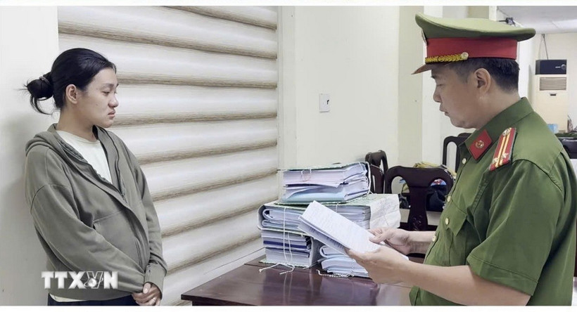 Công an đọc lệnh khởi tố đối với bị can trong đường dây mua bán trái phép hóa đơn. (Ảnh: TTXVN phát)