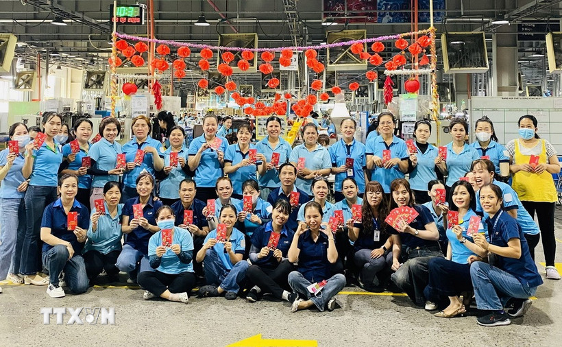 Lì xì công nhân Công ty Chang Shin Việt Nam trong ngày làm việc đầu tiên sau kỳ nghỉ Tết. (Ảnh: TTXVN phát)