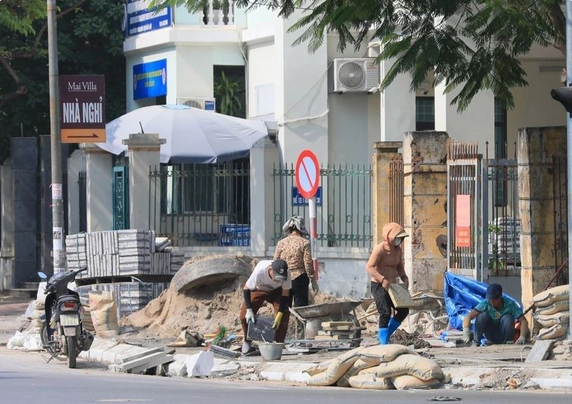 Công nhân xây dựng đang gấp rút hoàn thành vỉa hè. (Ảnh: Hoàng Hiếu/TTXVN)