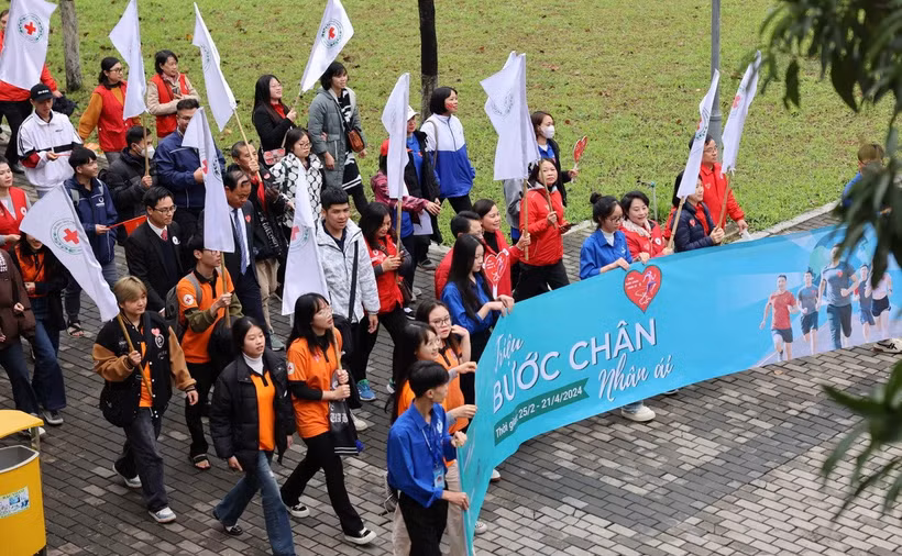 Đại biểu cán bộ, hội viên, tình nguyện viên Chữ thập Đỏ cùng sinh viên đi bộ hưởng ứng ngay sau phát động Chiến dịch "Triệu Bước chân nhân ái." (Ảnh: Thanh Tùng/TTXVN)