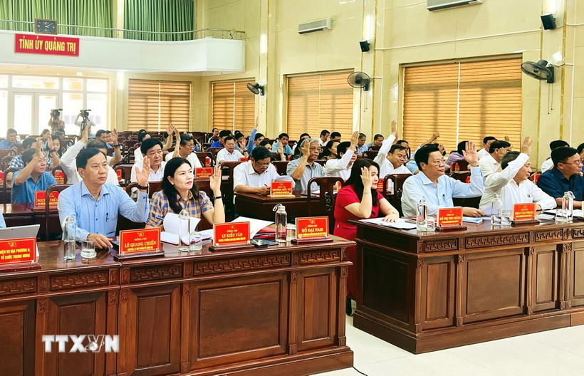 Các đại biểu biểu quyết thông qua Tờ trình về sắp xếp đơn vị hành chính cấp xã và chủ trương hợp nhất tỉnh Quảng Bình với tỉnh Quảng Trị. (Ảnh: Nguyên Linh/TTXVN)