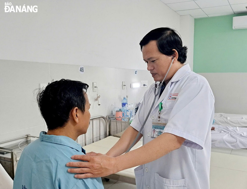 Bác sỹ Thân Trọng Vũ, Trưởng Khoa Ngoại lồng ngực (bên phải) kiểm tra sức khỏe cho bệnh nhân N.T.K trước khi làm thủ tục xuất viện. (Nguồn: báo Đà Nẵng)