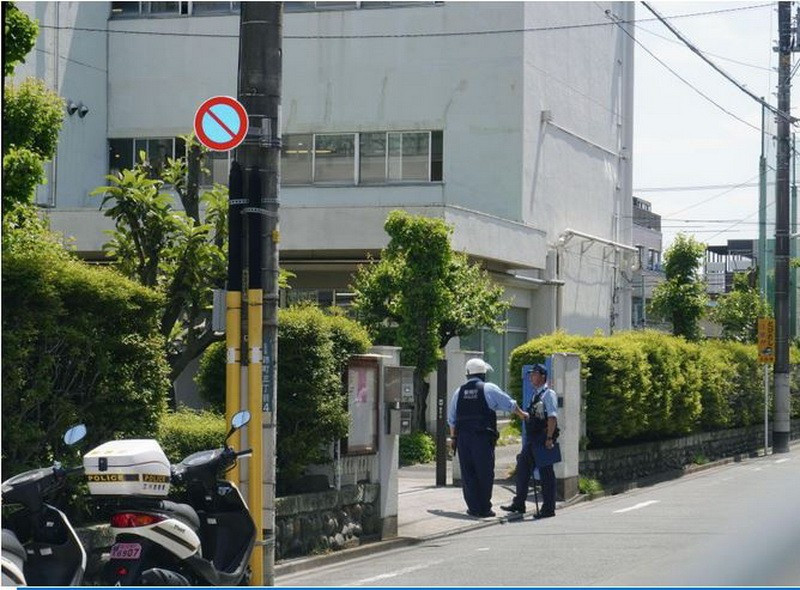 Cảnh sát đứng ở lối vào một trường tiểu học công lập ở Tachikawa, phía tây Tokyo, vào ngày 8/5, sau khi 2 người đàn ông bị bắt vì đột nhập vào trường và làm bị thương 5 giáo viên. (Nguồn: Kyodo)