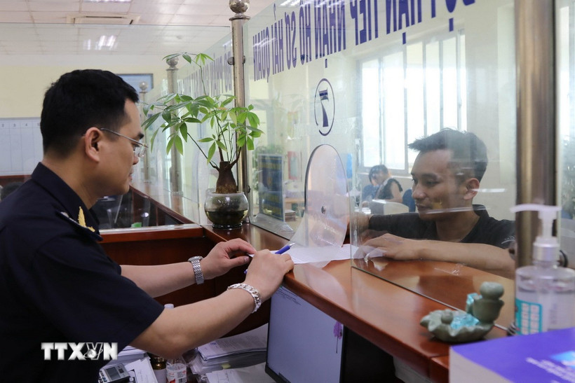 Công chức Chi cục Hải quan cửa khẩu Chi Ma hướng dẫn doanh nghiệp làm thủ tục xuất nhập khẩu hàng hóa. (Ảnh: Quang Duy/TTXVN)