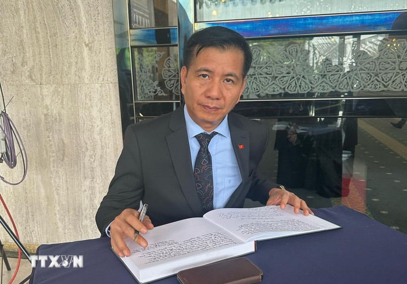 Đại sứ Đinh Ngọc Linh viết sổ tang tại lễ viếng cố Thủ tướng Abdullah bin Ahmad Badawi. (Ảnh: Hằng Linh/TTXVN)