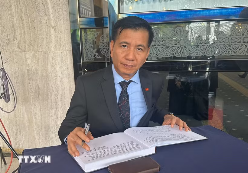 Đại sứ Đinh Ngọc Linh viết sổ tang tại lễ viếng cố Thủ tướng Abdullah bin Ahmad Badawi. (Ảnh: Hằng Linh/TTXVN)