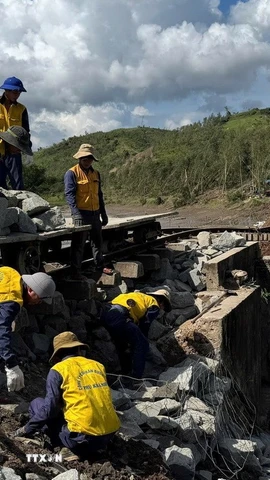 Các công nhân gia cố phần móng đường sắt bị sạt lở do bão số 13 ở xã Xuân Lãnh (tỉnh Đắk Lắk) . (Ảnh: Tường Quân/TTXVN)