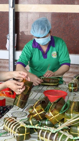 Người lao động làm bánh tét tại cơ sở sản xuất bánh tét Ba Loan, làng nghề bánh tét Trà Cuôn. (Ảnh: Thanh Hòa/TTXVN)