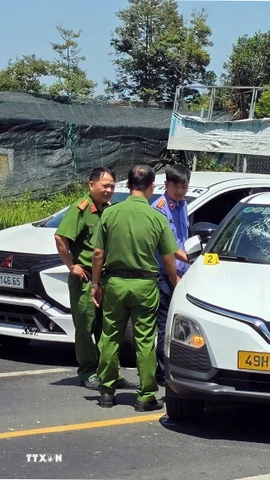 Cơ quan chức năng khám nghiệm hiện trường vụ việc đối tượng đập phá chiếc xe taxi do mâu thuẫn gia đình tại phường B'Lao. (Ảnh TTXVN phát)