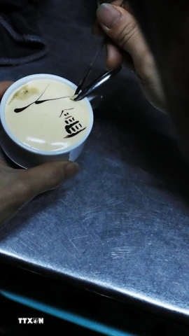 Người pha chế trang trí cho ly càphê trứng với hình ảnh Tháp Rùa. (Ảnh: Lâm Khánh/ TTXVN)