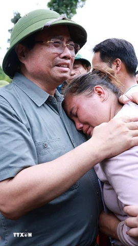Thủ tướng Phạm Minh Chính động viên gia đình có người chết do mưa lũ ở xã Xa Dung. (Ảnh: Dương Giang/TTXVN)
