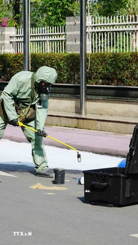 Lực lượng chức năng tiến hành thu hồi nguồn phóng xạ. (Ảnh: Thu Hoài/TTXVN)