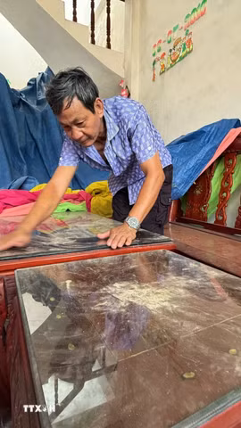 Dù đã khóa kín cửa nhưng bụi vẫn bám đầy trong nhà anh Nguyễn Thanh Liêm ở thôn Minh Tân Bắc, xã Mỏ Cày, tỉnh Quảng Ngãi. (Ảnh: Cao Nguyên/TTXVN)