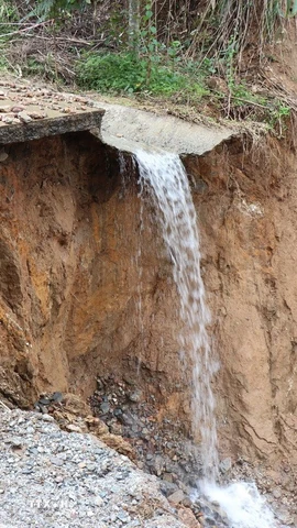 Tuyến đường ĐH83, đoạn Km8+200 qua thôn Tà Vinh, trục “xương sống” chạy dọc phía Tây xã Sơn Tây Hạ bị đứt gãy với chiều dài 40m, gây chia cắt giao thông. (Ảnh: Phạm Cường/TTXVN)