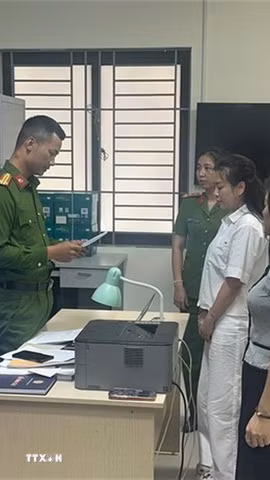 Kiểm sát viên Viện Kiểm sát Nhân dân tỉnh Thanh Hóa kiểm sát việc tống đạt Quyết định khởi tố và Lệnh tạm giam đối với bị can Trịnh Thị Vân Anh và Nguyễn Thị Thanh Ngần. (Ảnh: TTXVN phát)