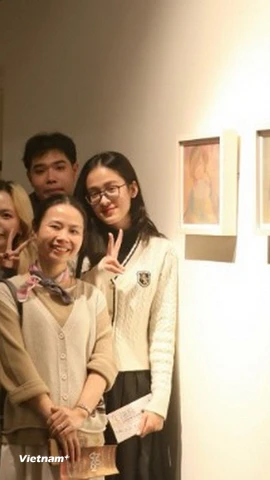 Võ Đình Lân và Vũ Yến Nhi - Ban Tổ chức triển lãm “Nữ Thời” - chụp ảnh cùng 2 họa sỹ. (Nguồn: Vietnam+)