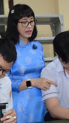 Cô Nguyễn Thị Diệu Hạnh hướng dẫn đội tuyển học sinh giỏi sinh thực hành. (Ảnh: Văn Dũng/TTXVN)