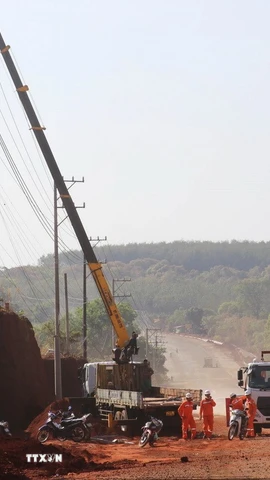 Cán bộ, công nhân điện lực Đồng Nai tiến hành di dời hơn 30 trụ điện phục vụ mở rộng tuyến đường ĐT.753. (Ảnh: Đậu Tất Thành/TTXVN)