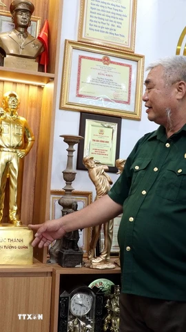 Cựu chiến binh Phan Trọng Điền (trái) giới thiệu sản phẩm đúc đồng của công ty. (Ảnh: Nguyễn Lành/TTXVN)