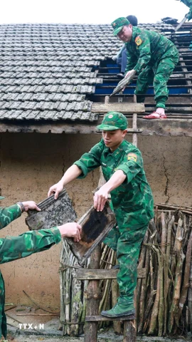 Lực lượng Đồn Biên phòng Tùng Vài (Tuyên Quang) giúp người dân lợp lại mái nhà cho người dân bị ảnh hưởng của mưa đá, dông lốc. (Ảnh: Đức Thọ/TTXVN)