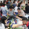 Lưu học sinh thích thú với hoạt động gói bánh chưng chuẩn bị đón Xuân Ất Tỵ. (Ảnh: Ngọc Khương/TTXVN)