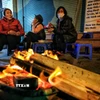 Người dân mang củi ra đốt sưởi ấm. (Ảnh: Thành Đạt/TTXVN)