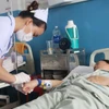 Nhân viên y tế chăm sóc bệnh nhân mắc sởi. (Ảnh: Đinh Hằng/TTXVN)