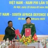 Thượng tướng Hoàng Xuân Chiến, Thứ trưởng Bộ Quốc phòng Việt Nam, và bà Thobekile Gamede, Quyền Tổng Thư ký Quốc phòng Nam Phi, ký biên bản ghi nhớ về hợp tác quốc phòng giữa hai nước. (Ảnh: Trọng Đức/TTXVN)