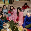 Cán bộ Đại sứ quán và người Việt tại Israel tham gia gói bánh chưng. (Ảnh: Đức Trung/TTXVN)