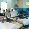 Cán bộ tiếp nhận hồ sơ giải quyết thủ tục cho người dân tại Trung tâm Phục vụ hành chính công phường Tân Ninh (Tây Ninh). (Ảnh: Minh Phú/TTXVN)