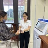 Cán bộ phường Vĩnh Phúc, tỉnh Phú Thọ hỗ trợ người dân đăng ký, lấy số khi làm thủ tục hành chính. (Ảnh: Nguyễn Thảo/TTXVN)