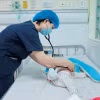 Bác sỹ khám cho bệnh nhi mắc ho gà đang điều trị tại Trung tâm bệnh Nhiệt đới (Bệnh viện Nhi Trung ương). (Ảnh: Minh Quyết/TTXVN)