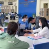 Cán bộ Trung tâm Phục vụ-Kiểm soát thủ tục hành chính tỉnh Quảng Ngãi hướng dẫn trực tiếp người dân đến làm thủ tục hành chính. (Ảnh: Hải Âu/TTXVN)